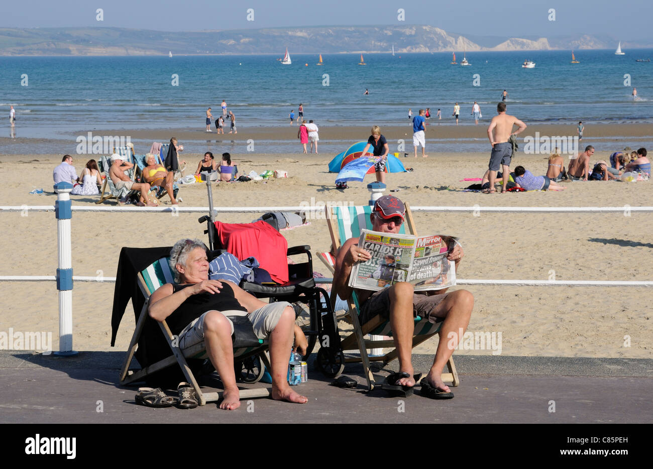 Ältere Urlauber sitzen in Liegestühlen in das Seebad Weymouth Dorset England UK Stockfoto