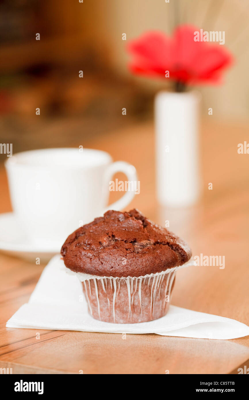 Frühstück-Muffin mit Kaffeetasse in einem gemütlichen Wohnlandschaft Stockfoto