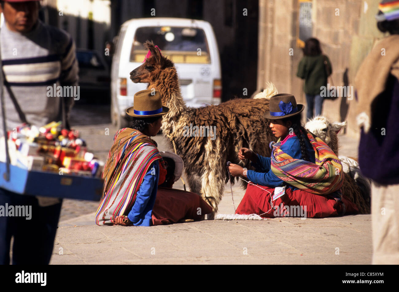 Cusco, Peru. Zwei Frauen in bunten Trachten mit einem Lama. Stockfoto
