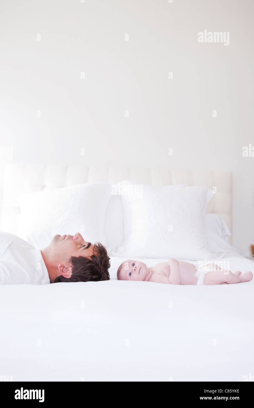 Papa und Baby auf Bett Stockfoto