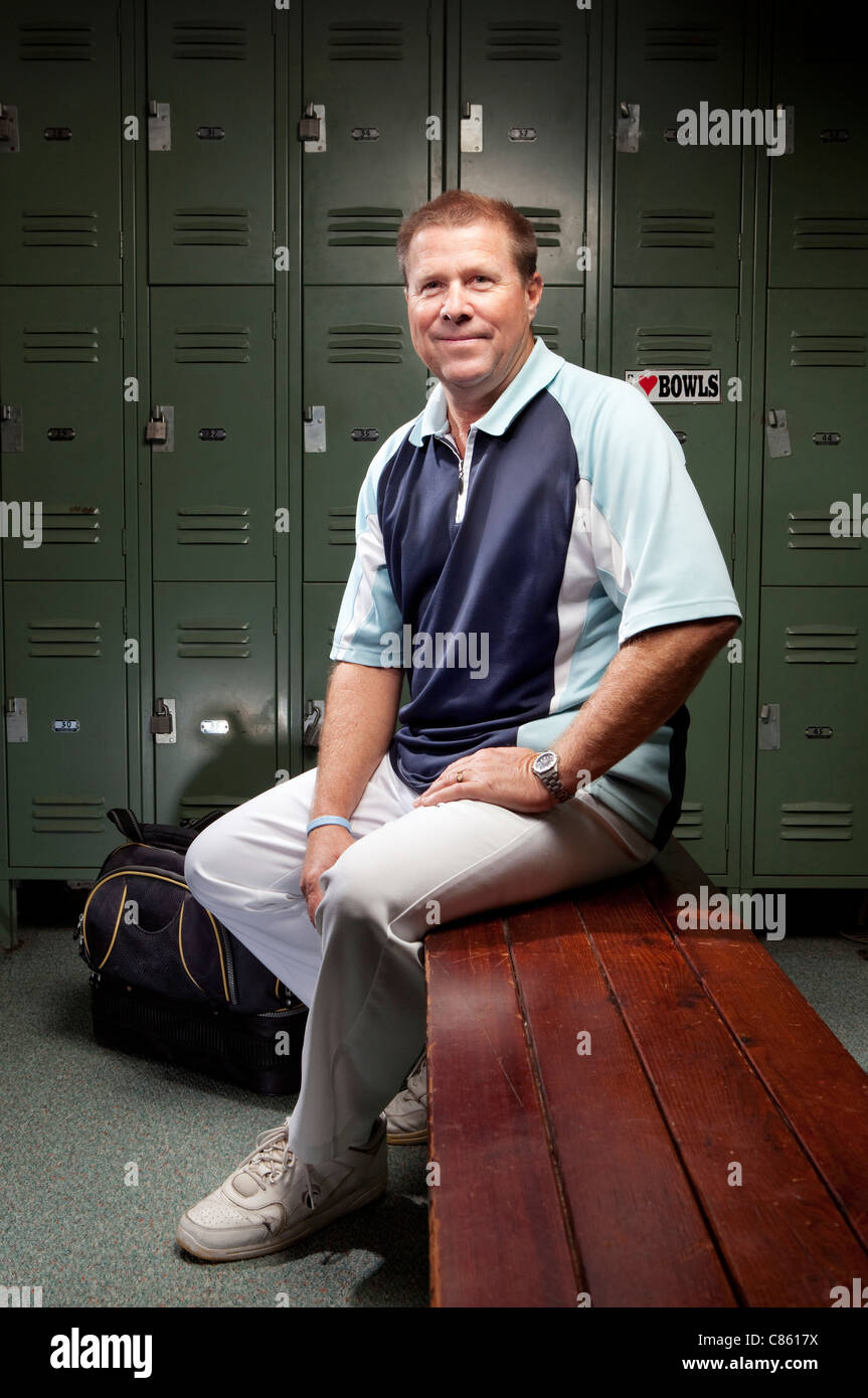 Kaukasischen Mann sitzt auf der Bank im Umkleideraum Stockfoto