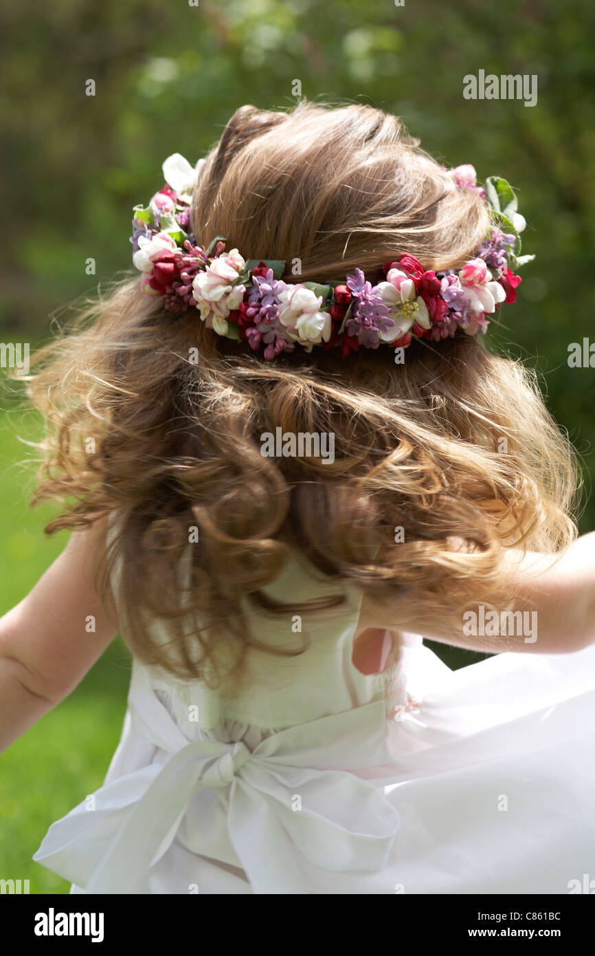 Kleines Mädchen mit einem Blumen-Kranz im Haar drehen Stockfoto