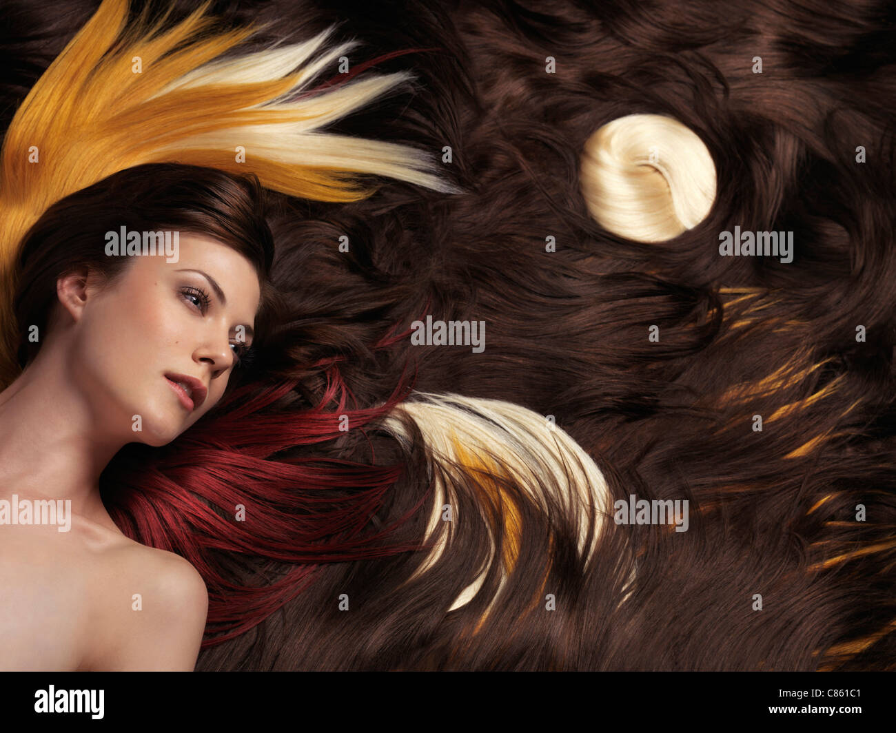 Künstlerische Fotos von einer schönen Frau mit langen braunen Haaren und künstlerisch gestalteten bunten Haarverlängerungen Stockfoto
