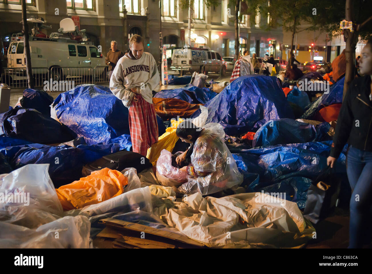 Besetzen Sie Wall Street Demonstranten im Zuccotti Park in Lower Manhattan in New York auf Mittwoch, 12. Oktober 2011 auf einem kalten, regnerischen Abend vorzubereiten.  NY Bürgermeister Michael Bloomberg besucht die Demonstranten heute Abend und sagte ihnen, dass der Park in Etappen ab Freitag Morgen gereinigt werden. Stockfoto