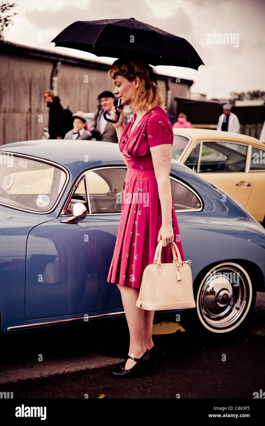 Frauen, gekleidet in historischen Kostümen neben einem Porsche 356 Stockfoto