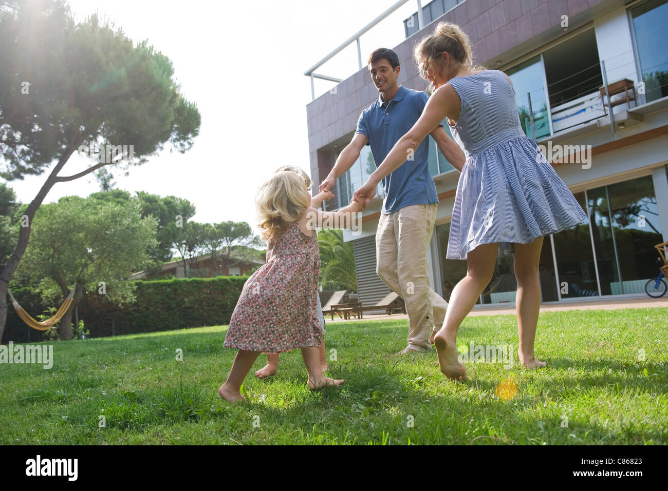 Familie spielen Ring-um-die-Rosy im freien Stockfoto