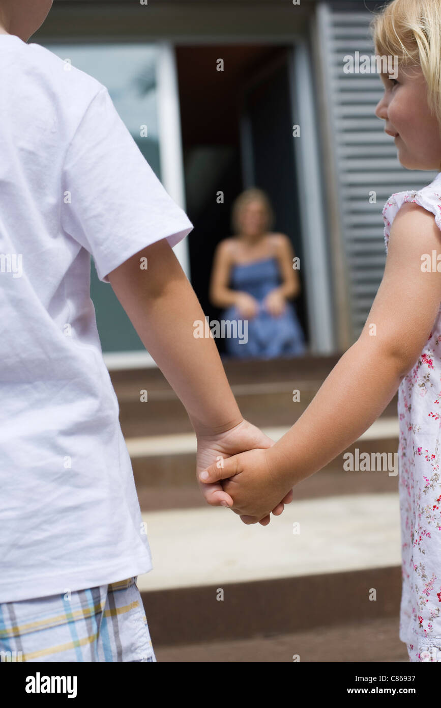 Junge Geschwister Hand in Hand im Freien, Rückansicht Stockfoto