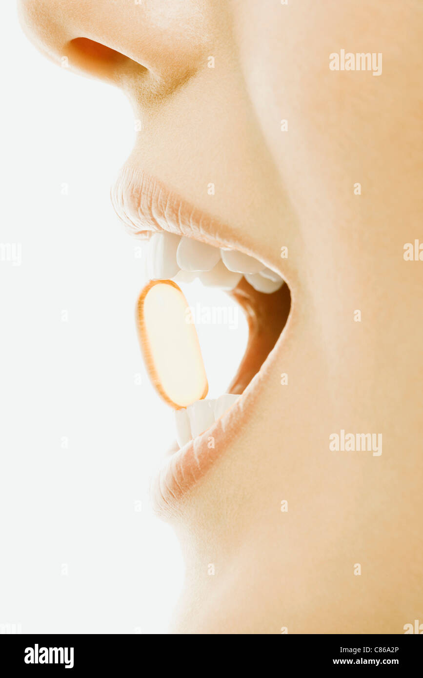 Frau mit weichen Gel-Kapsel Vitamin zwischen Zähnen, Nahaufnahme Stockfoto