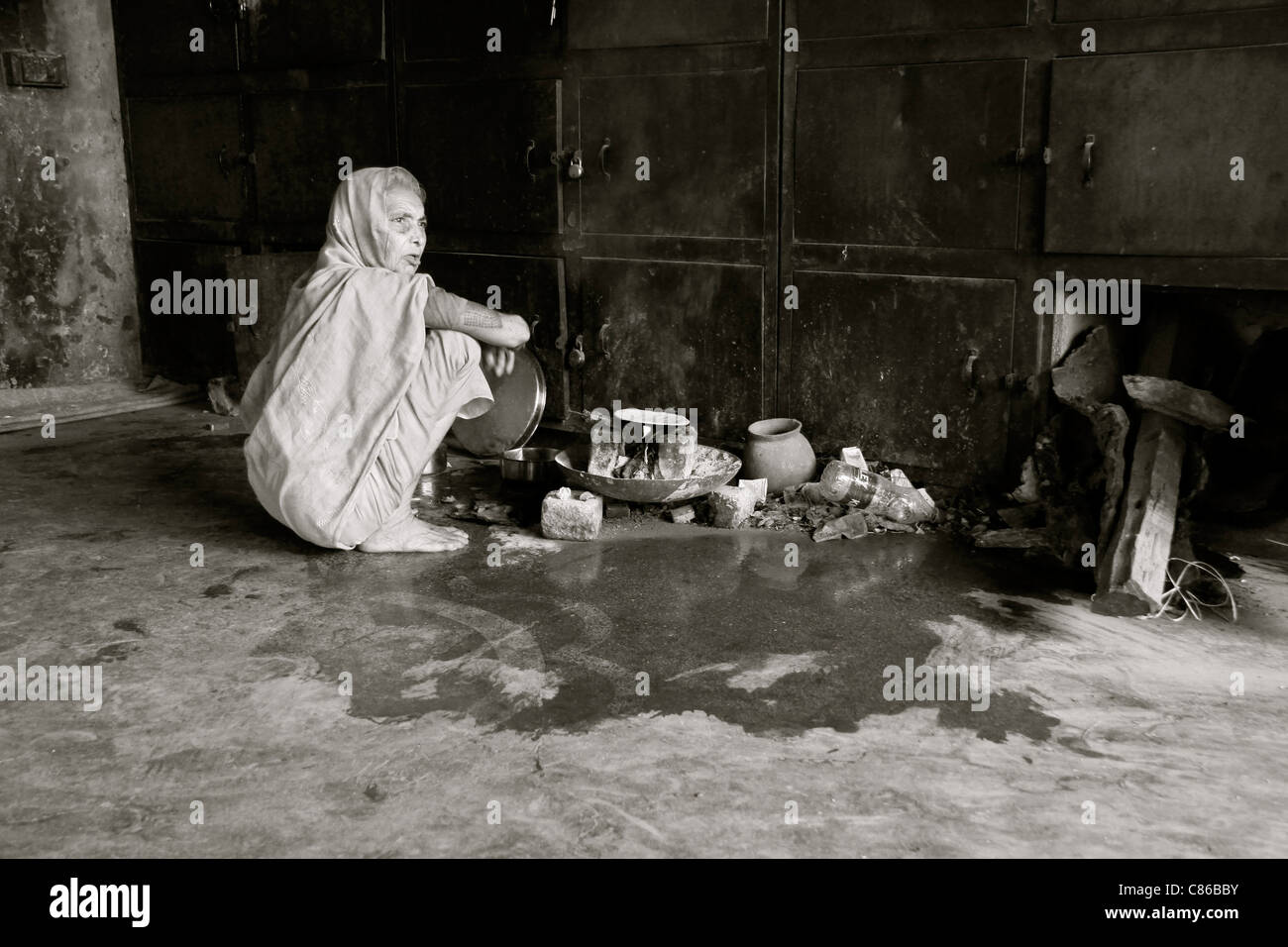 Obdachlose Frau Kochen auf einem provisorischen Herd in einem verlassenen Gebäude, Varanasi, Indien Stockfoto