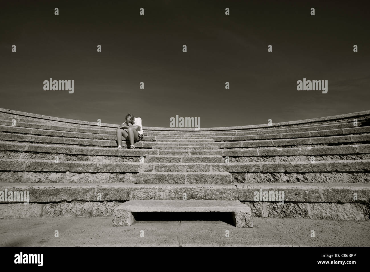 Junge sitzt alleine in einem leeren Amphitheater in Monte Carlo, Monaco Stockfoto