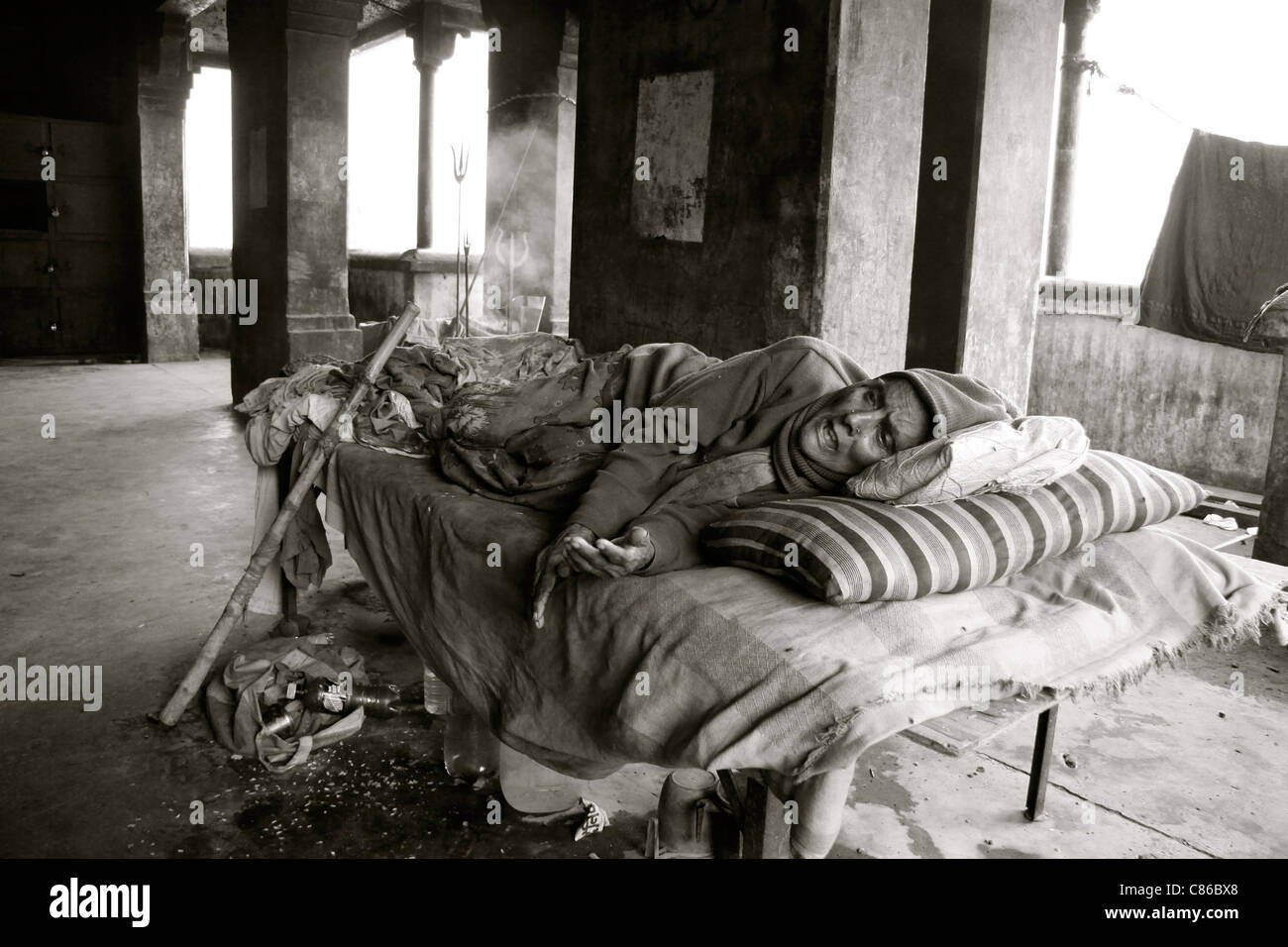 Eine sterbende Frau liegt auf einem Bett in einem verlassenen Gebäude, Varanasi, Indien Stockfoto