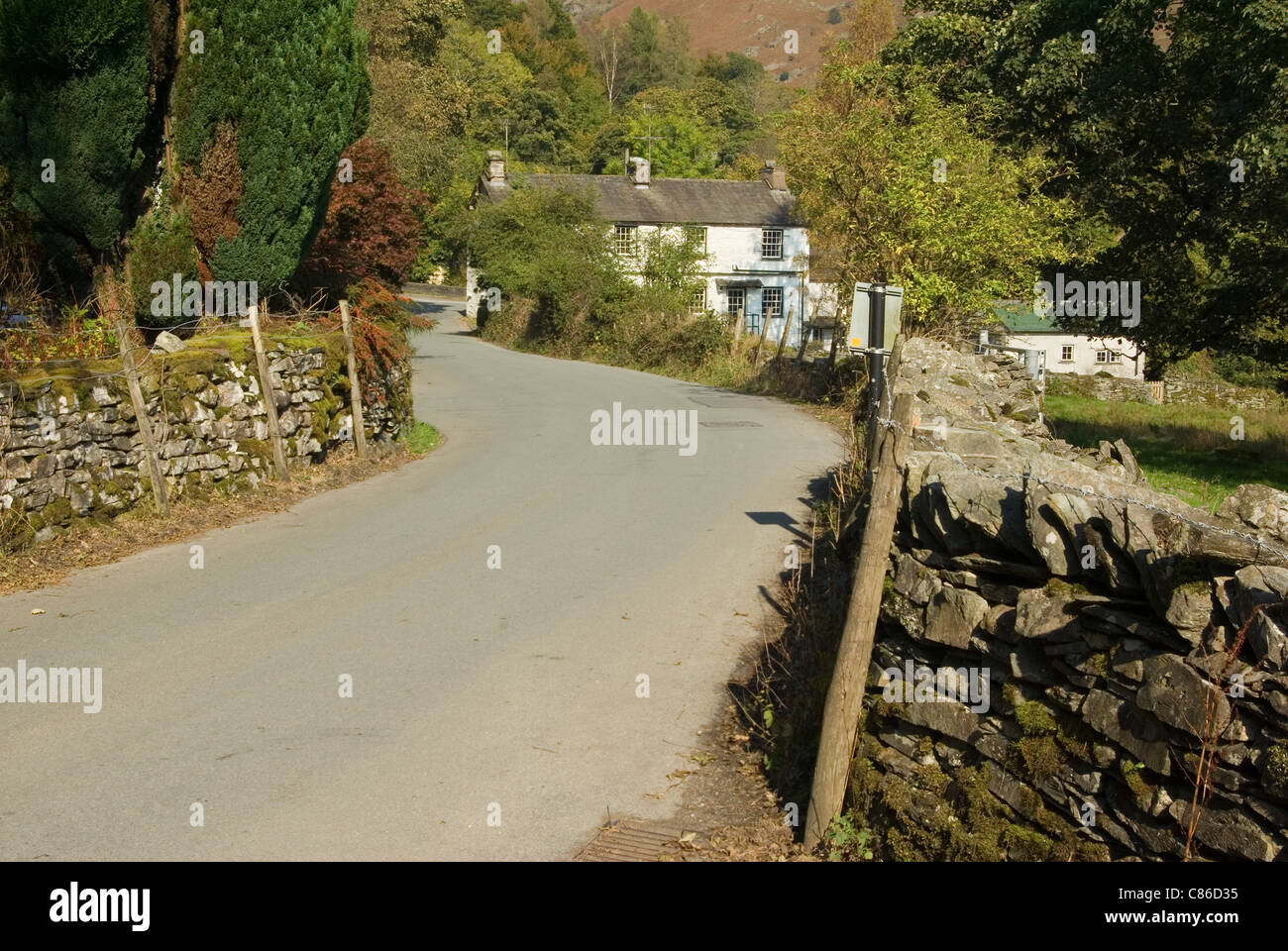 Feldweg führt durch Elterwater Dorf Stockfoto