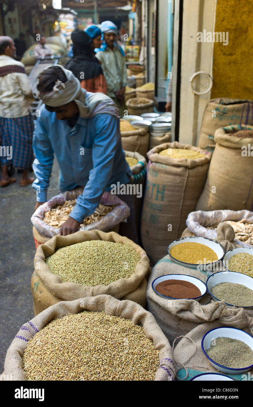 Standbesitzer mit Koriandersamen und getrocknete Mango Skins zum Verkauf an Khari Baoli Gewürze und getrocknete Lebensmittel-Markt, Alt-Delhi, Indien Stockfoto