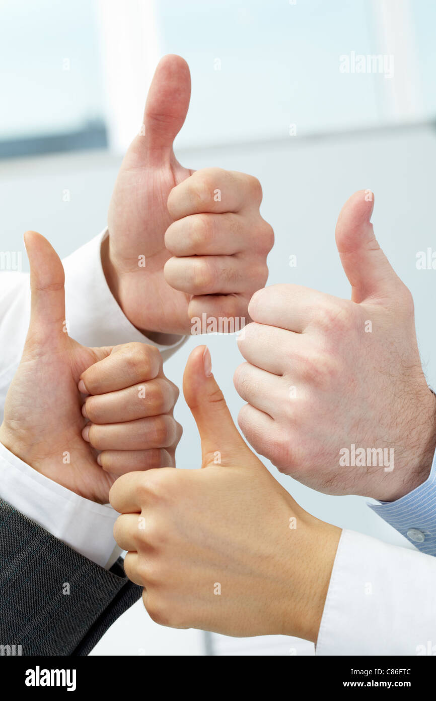 Nahaufnahme von vier Händen, Daumen zeigen Stockfoto