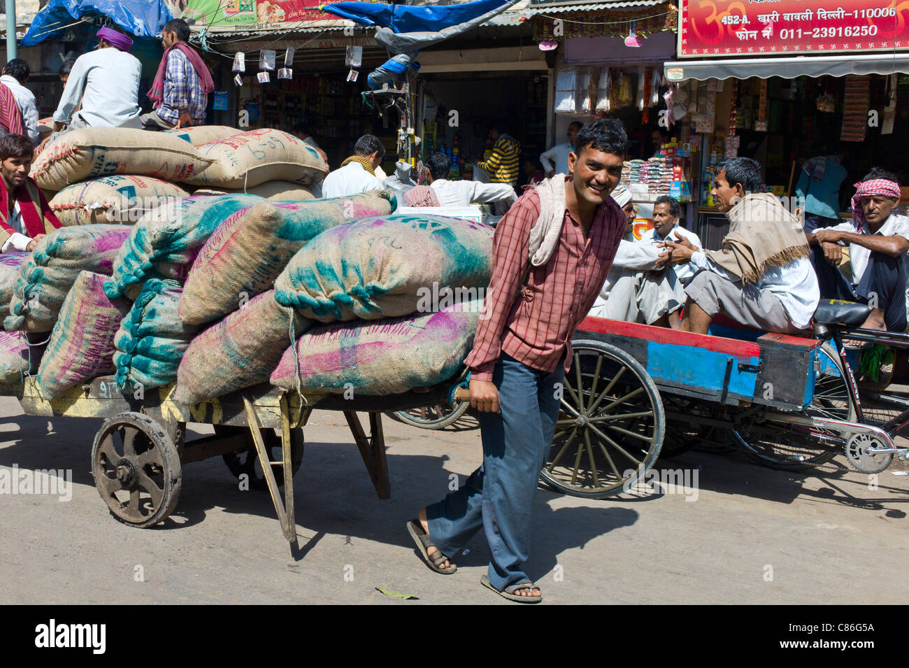 Träger mit Säcken von Terminen an Khari Baoli Gewürze und getrocknete Lebensmittel-Markt, Alt-Delhi, Indien Stockfoto