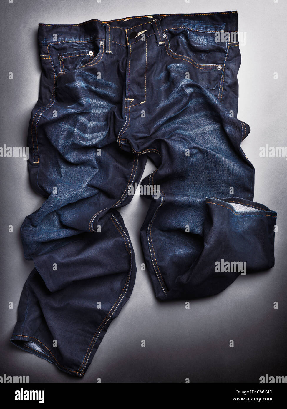 Foto von künstlerisch zerknitterten blauer Stein gewaschen Herren Jeans auf grauem Hintergrund Stockfoto
