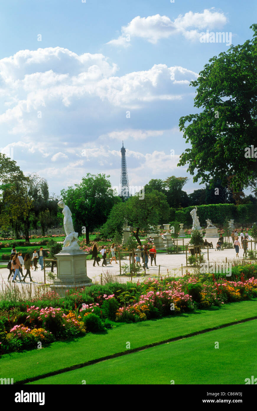 Blumen und Statuen in den Jardin Des Tuileries in der Nähe von Palais du Louvre in Paris mit Eiffelturm und Touristen am Wege Stockfoto