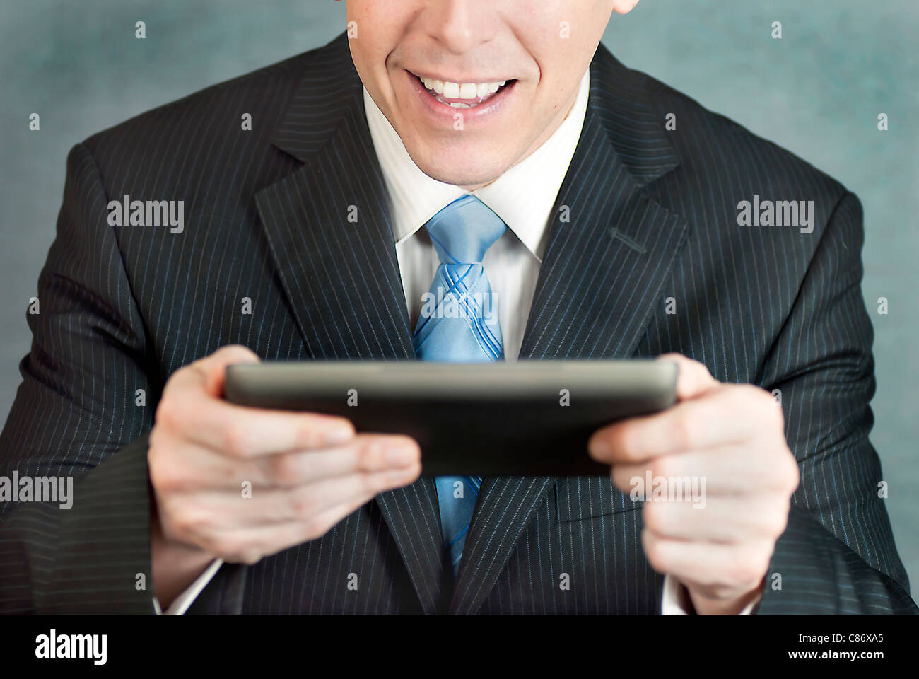 Eine Nahaufnahme eines Geschäftsmannes betrachten eines Tablet-Computers mit Aufregung. Stockfoto
