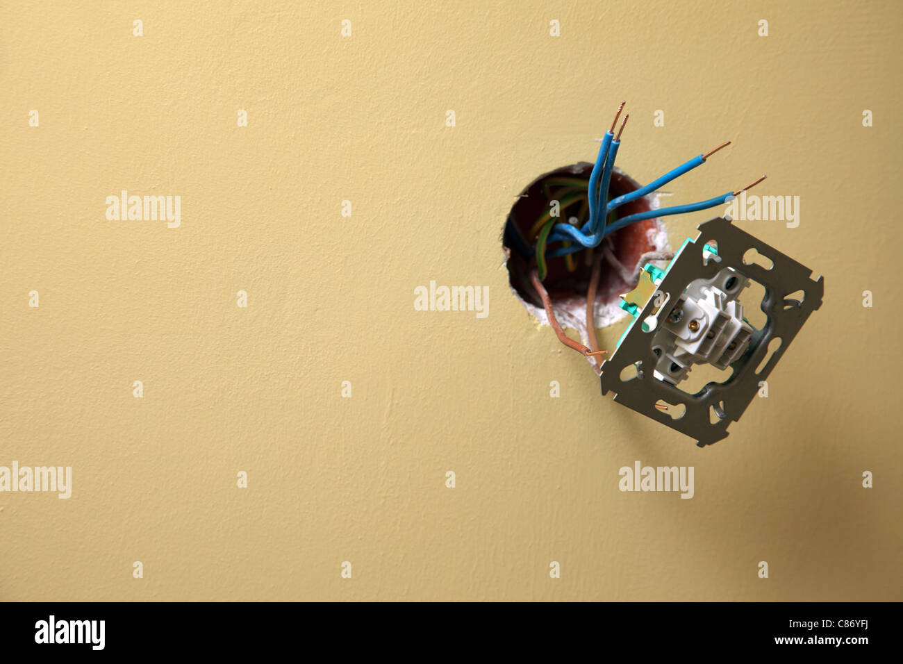 Elektriker installieren eine Power Socket Wand Hintergrund, schmutzige Steckdose aus der Wand hängen Stockfoto