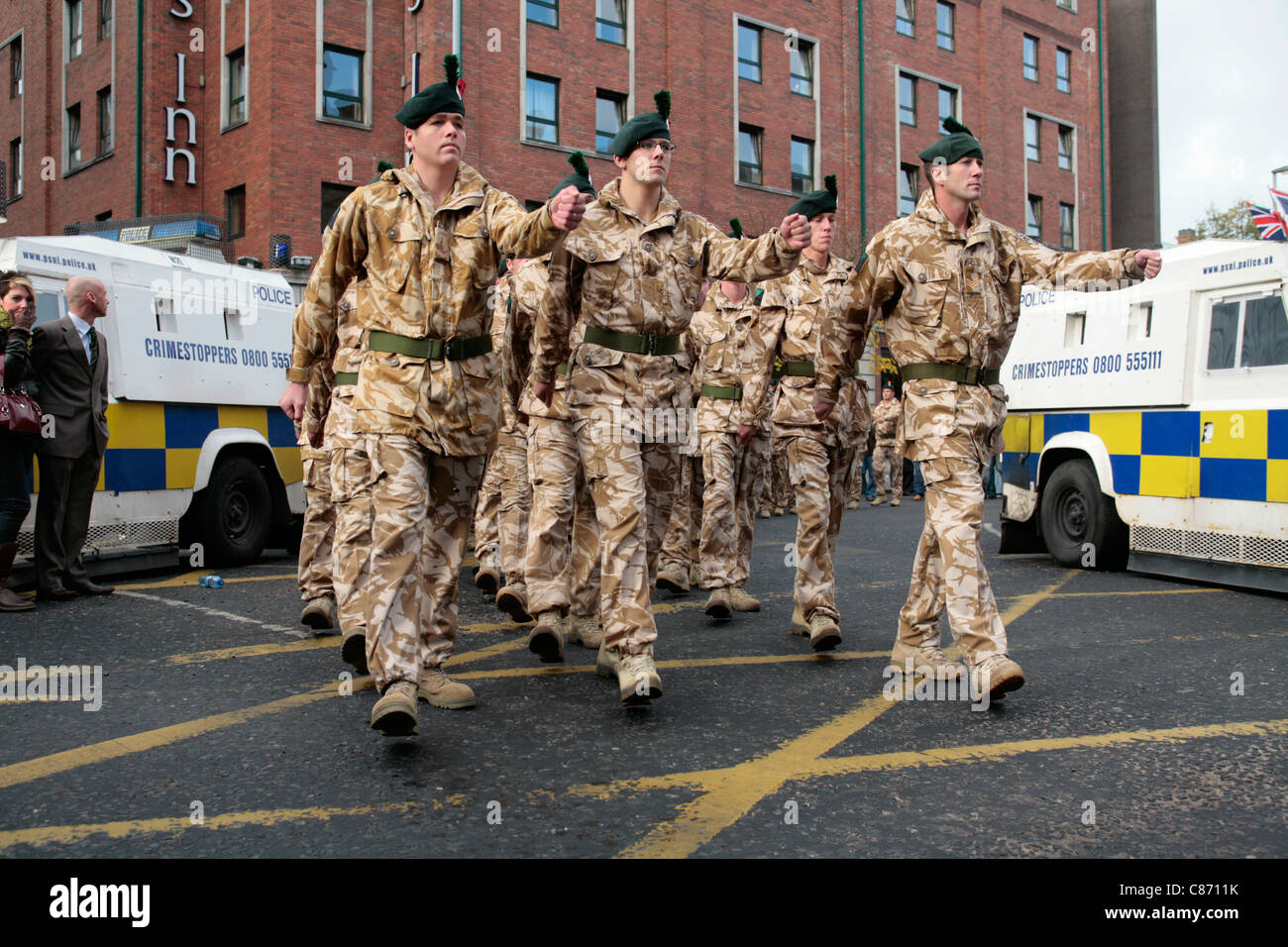 Soldaten des Royal Irish Regiment marschieren am 02. September 2008 in Belfast, Nordirland, zwischen Polizeilinien, die republikanische und loyalistische Demonstranten trennen. Die Parade, die relativ friedlich verlief, war für Truppen, die aus dem Irak und Afghanistan zurückkehrten Stockfoto