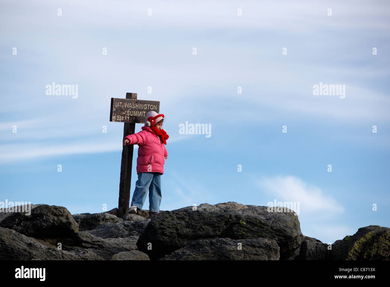 Eine Mädchen stellt durch das Zeichen auf dem Gipfel des Mt Washington in New Hampshire Stockfoto