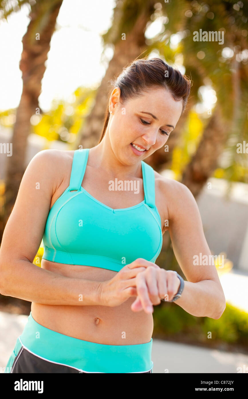 Frau, die Einstellung der Uhr für laufen, Long Beach, Kalifornien, USA Stockfoto