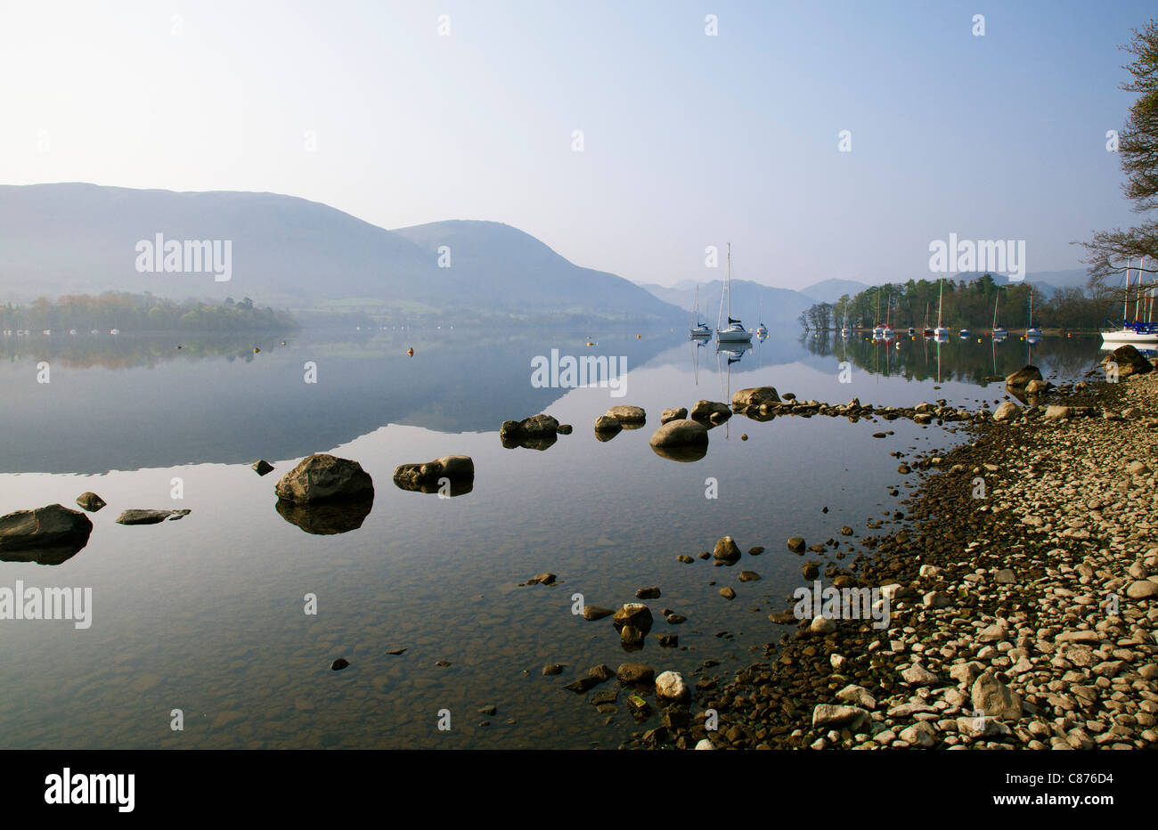 Ullswater-See in der Morgendämmerung mit Yachten und Reflexionen Stockfoto