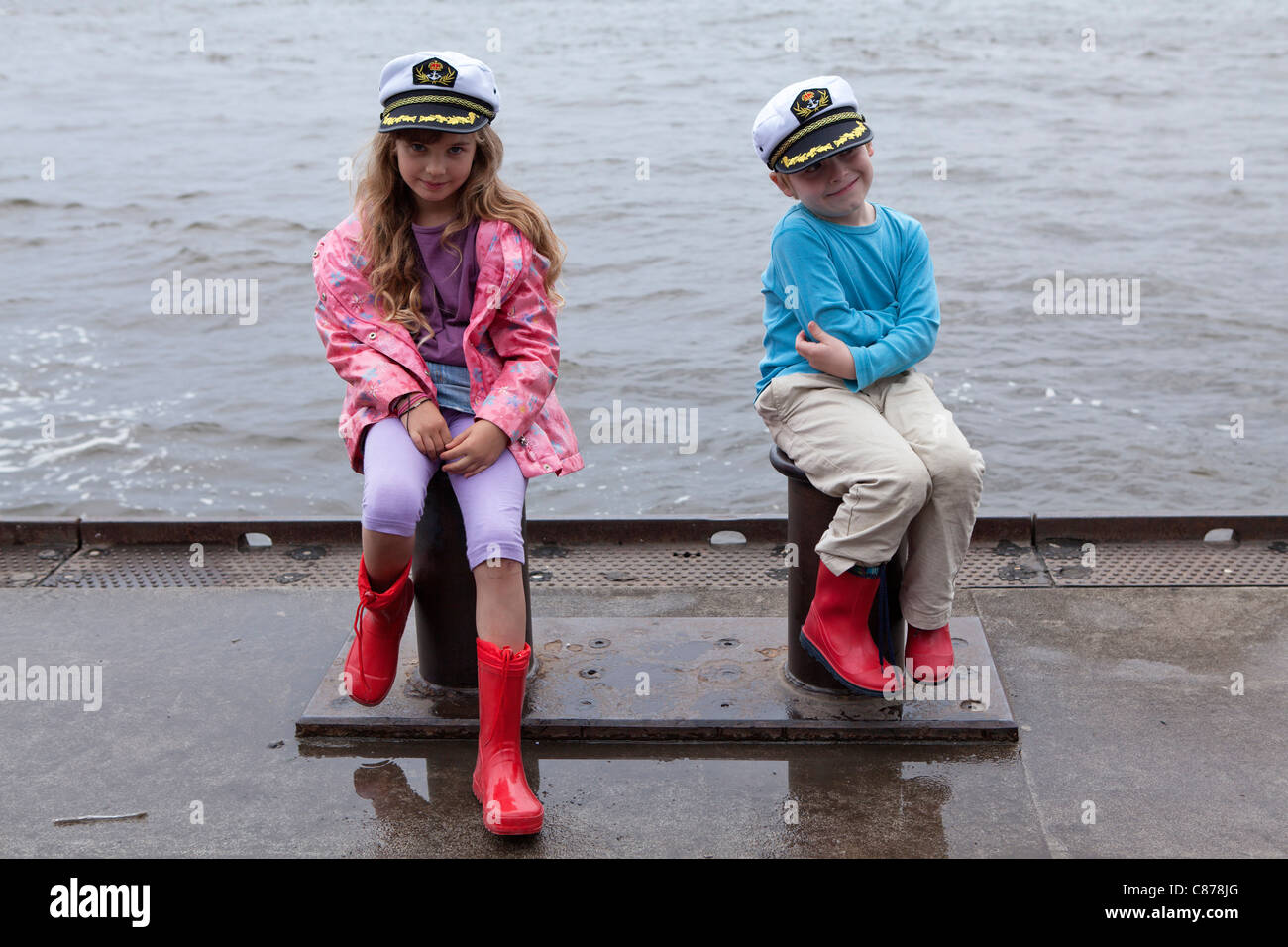 Kinder mit Sailor´s Hut sitzt auf Poller, Hamburger Hafen, Deutschland Stockfoto