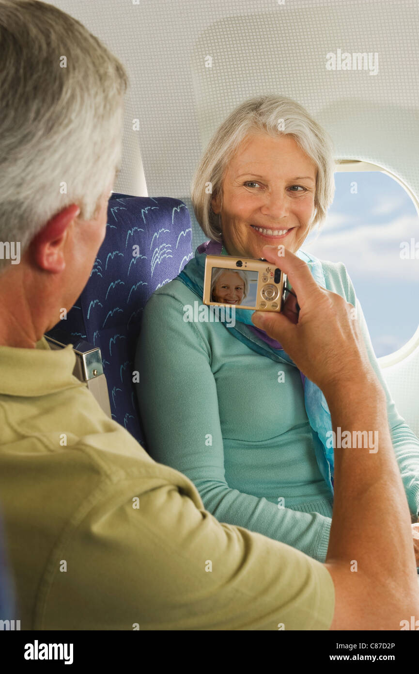 Deutschland, München, Bayern, älteres paar unter Bild vom Handy in Economy-Class-Verkehrsflugzeug Stockfoto