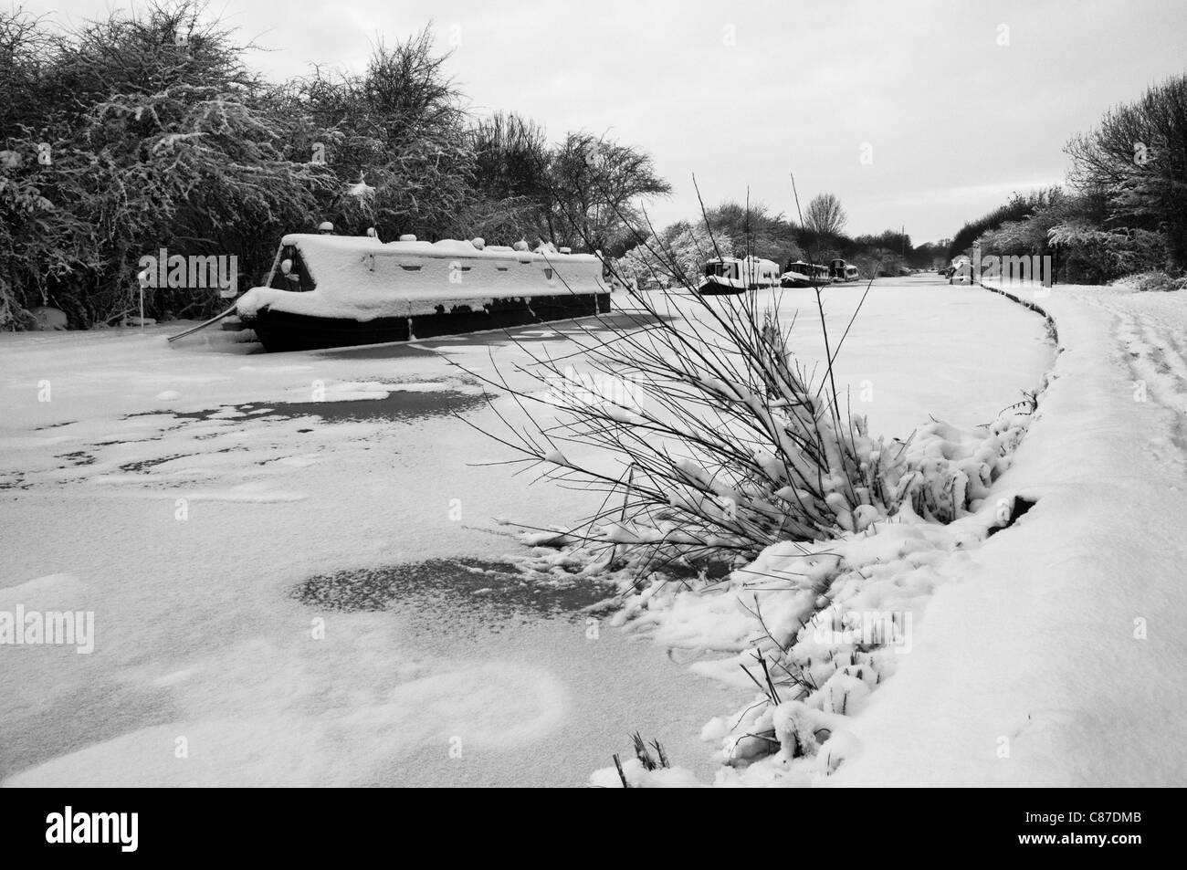 Gefrorene Grand Union Canal und Boote unter dem Schnee im Winter im Cosgrove, Northamptonshire, in der Nähe von Milton Keynes Stockfoto