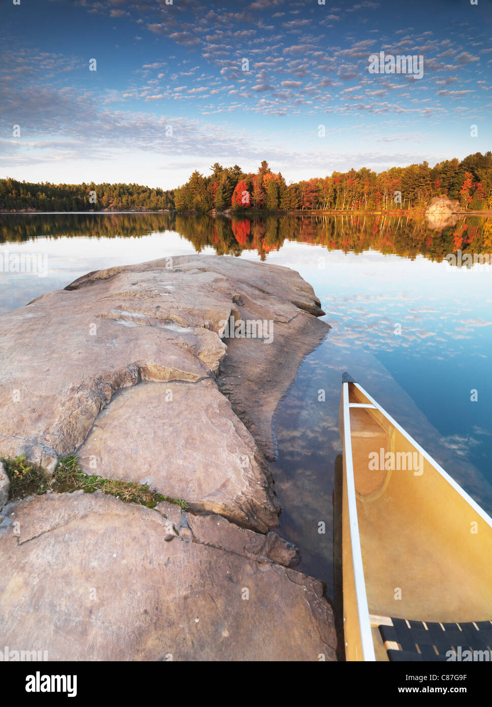 Kanu auf einem felsigen Ufer des Lake George. Schöner Sonnenuntergang Herbst Natur Landschaft. Killarney Provincial Park, Ontario, Kanada. Stockfoto