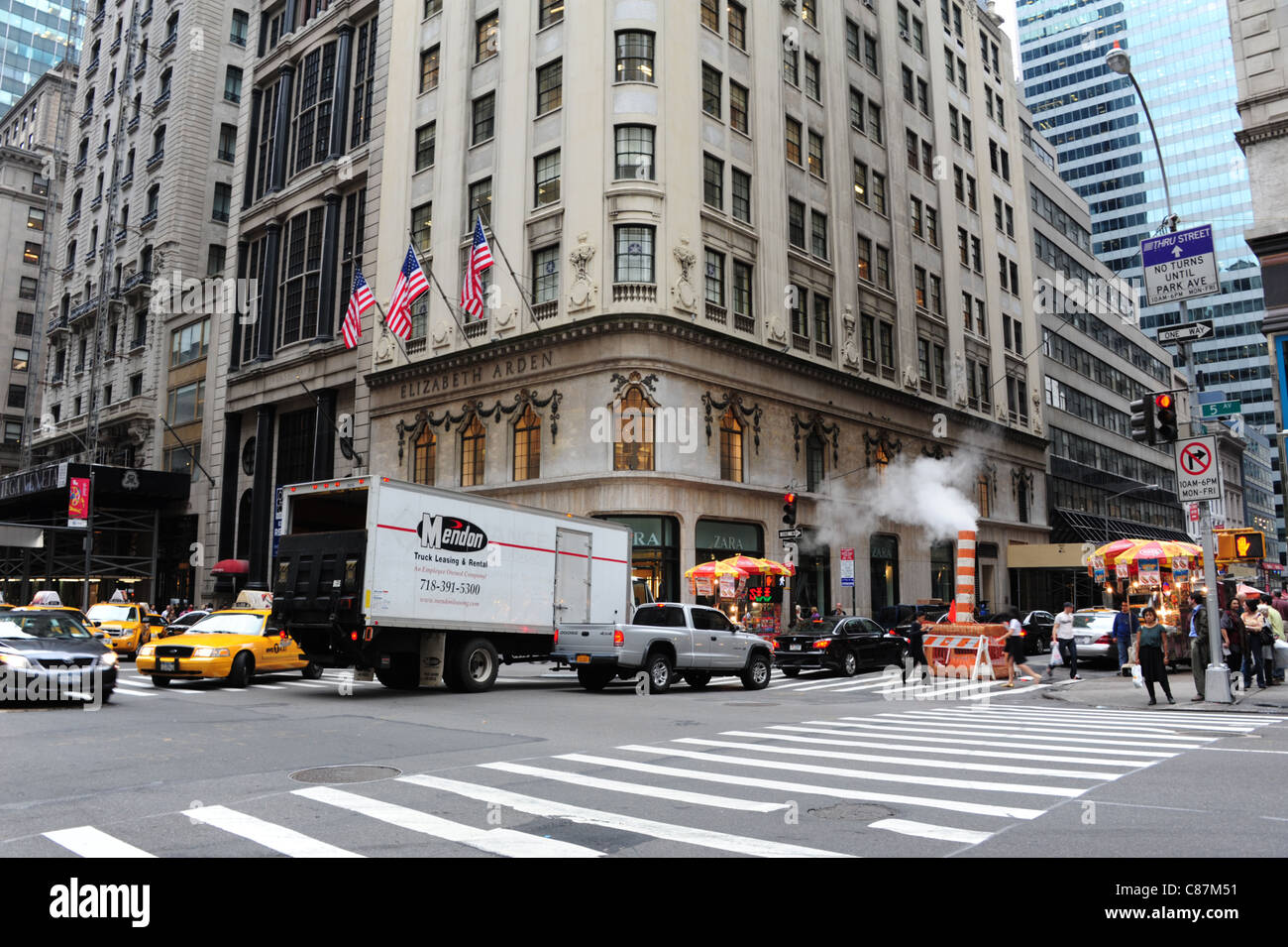 East 56th Street 5th Avenue-Straßenkreuzung, gelbe Taxis, Autos, weißen Lieferwagen, Personen, rot weiße Kunststoff Dampfventil, New York anzeigen Stockfoto