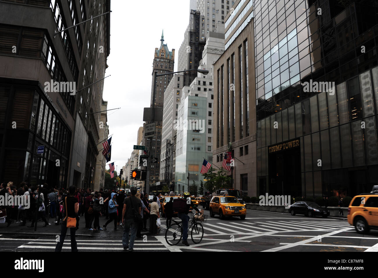 Menschen, Radfahrer, gelben Taxis, West 56th Street 5th Avenue Kreuzung zwischen Trump Tower, Abercrombie & Fitch Store, New York Stockfoto