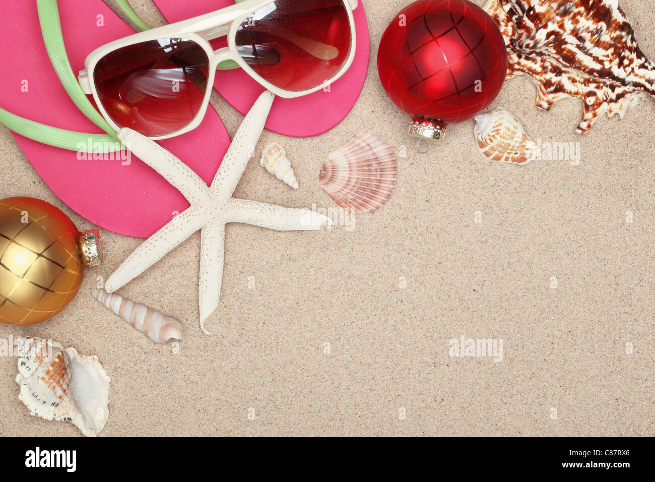 Weihnachtskugeln, Muscheln und mit Strand-Accessoires auf Sand, Nahaufnahme. Stockfoto