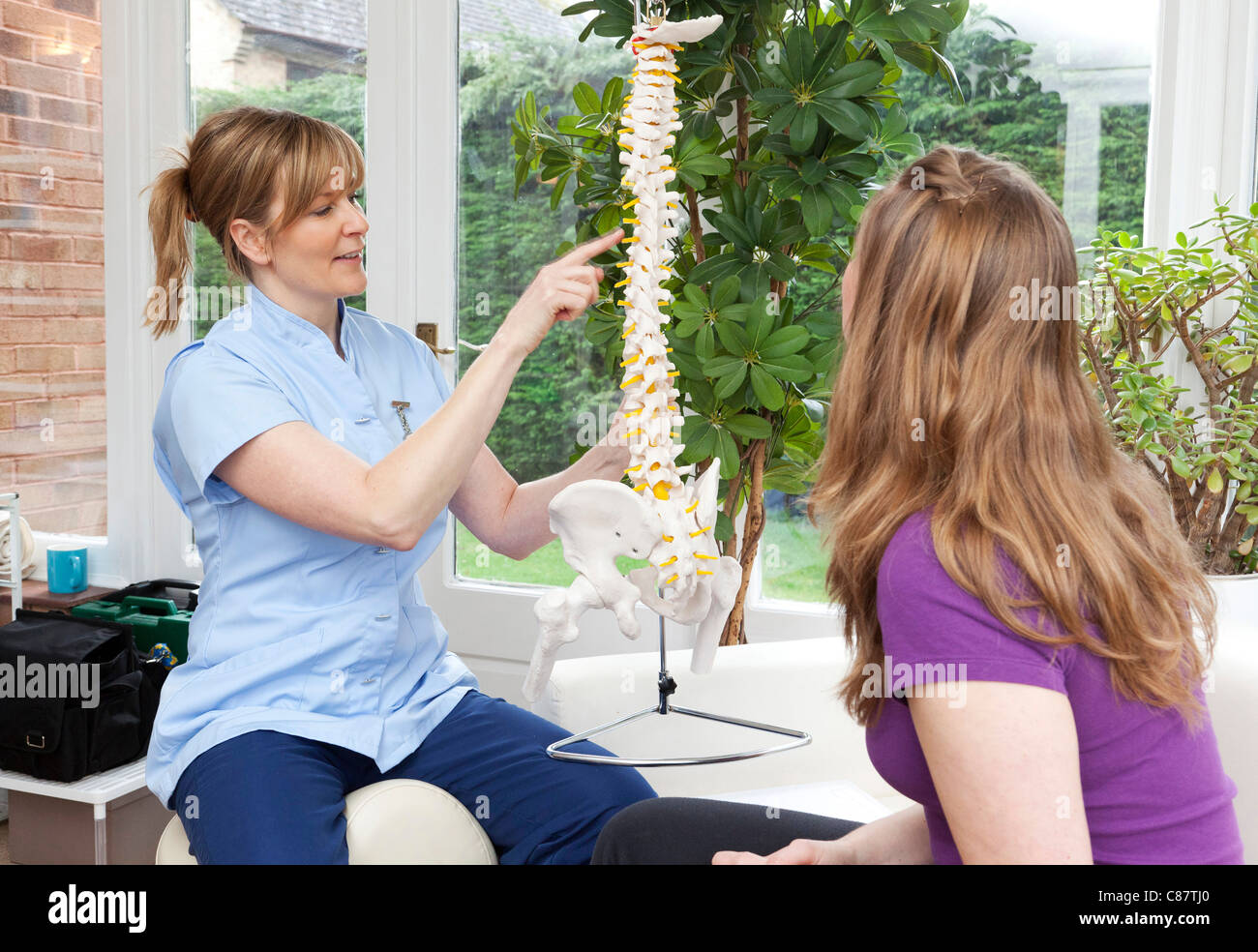 Osteomyologist im Gespräch mit einem Patienten in Großbritannien (eine Kombination der Chiropraktik und Osteopathie) Stockfoto