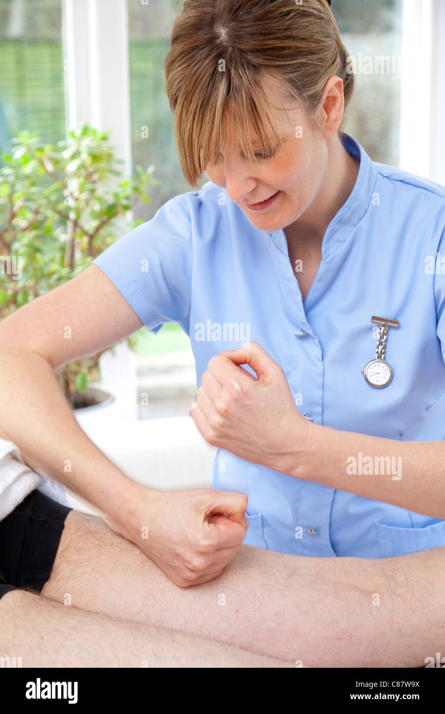 weibliche Massage Therapeut Behandlung von männlichen Patienten mit stampfenden / geprescht Aktion Stockfoto