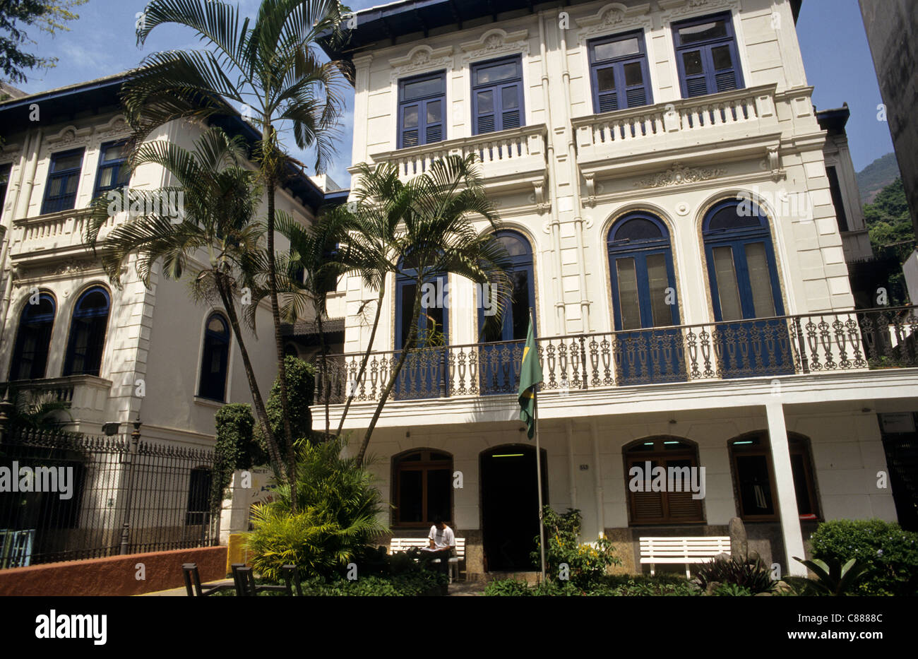 Rio De Janeiro, Brasilien. Großes Haus typisch für Laranjeiras Bezirk mit Palmen und eine brasilianische Flagge vor. Stockfoto