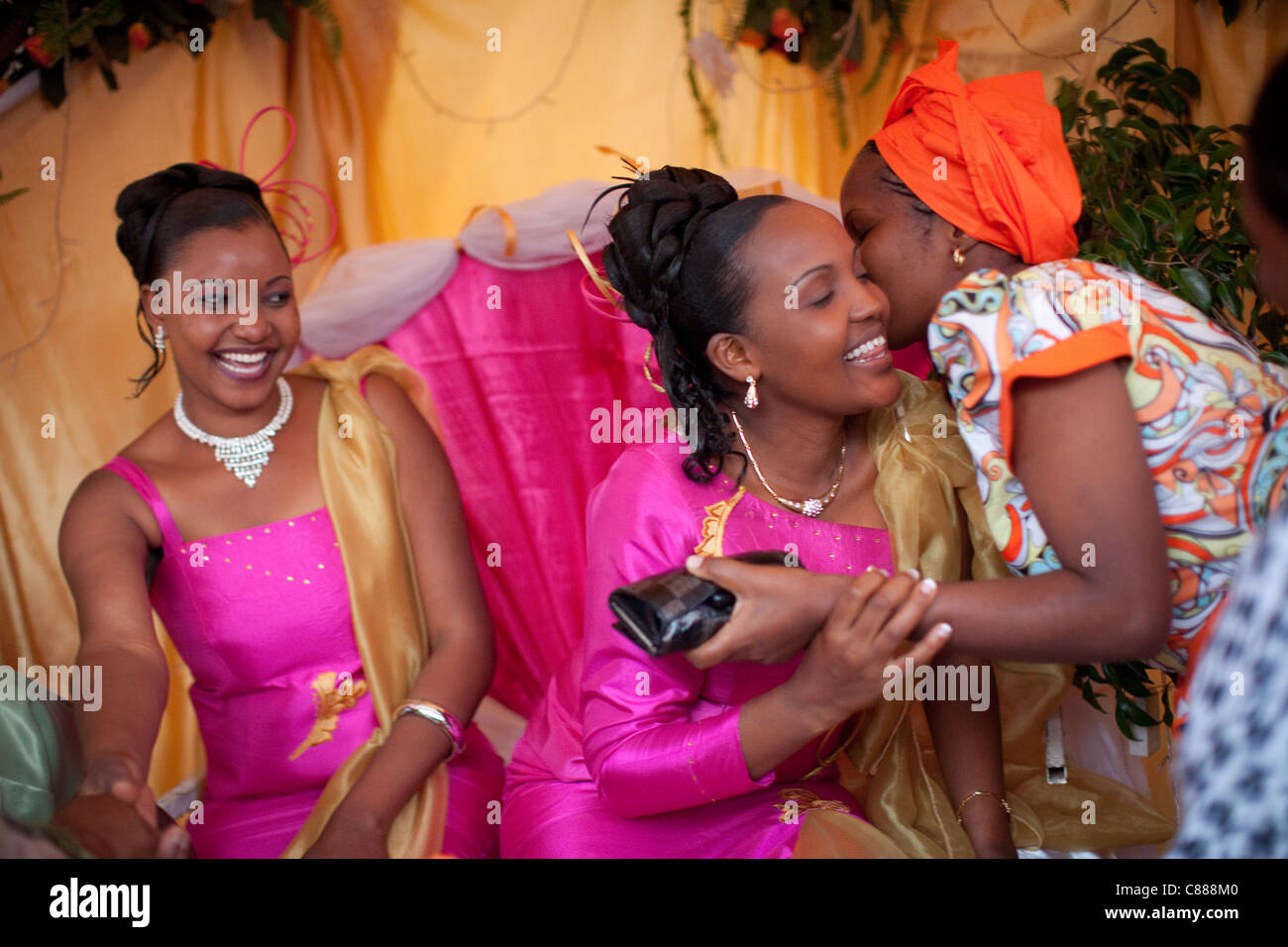 Frauen begrüßen einander bei einer Hochzeit außerhalb von Arusha, Tansania, Ostafrika. Stockfoto