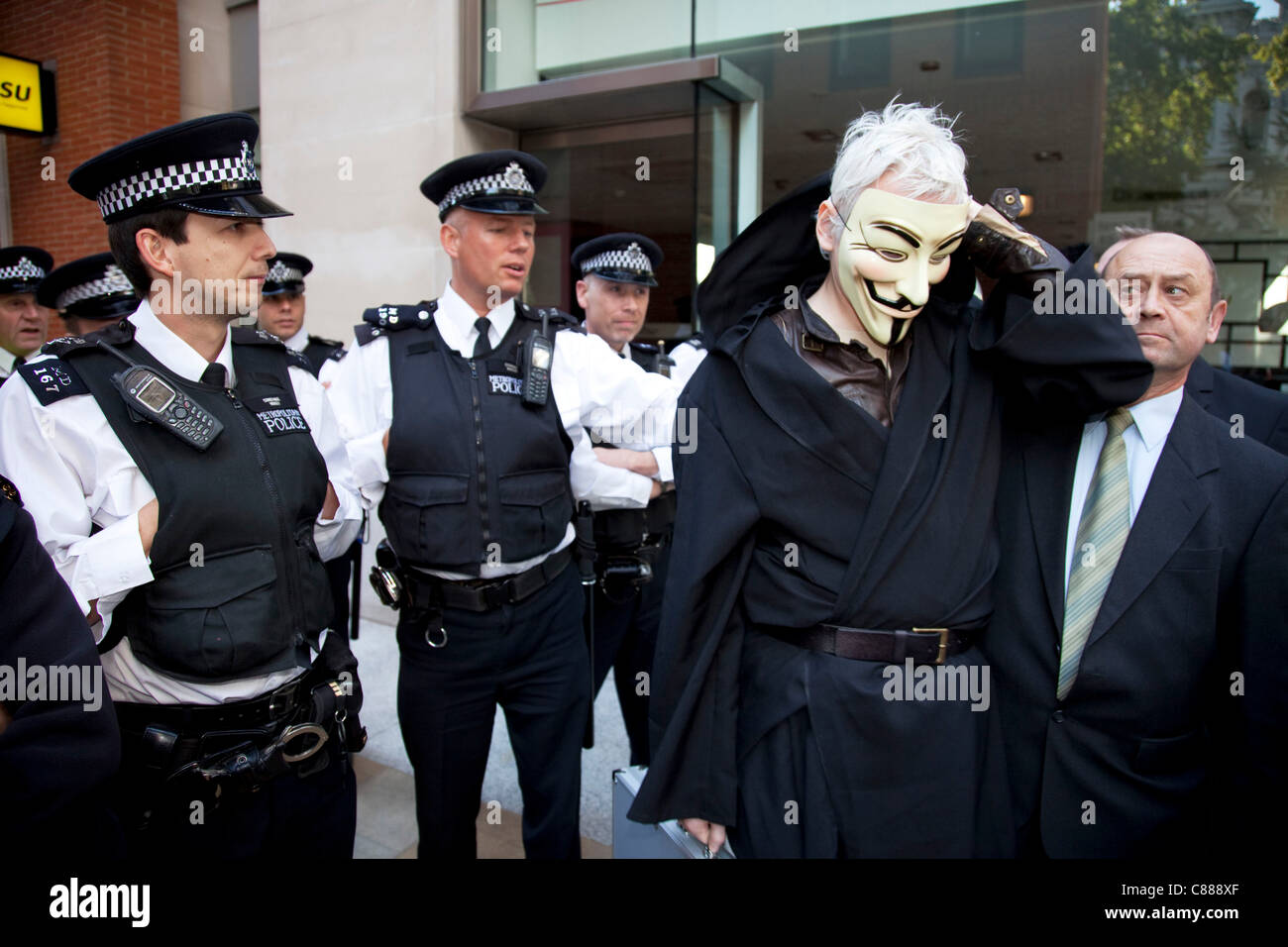 Julian Assange von WikiLeaks bei der Demonstration Occupy London 15. Oktober 2011. Hier zu sehen, versucht er durch die Polizeilinien tragen einen schwarzen Umhang, Kapuze und Maske zu bekommen. Sofort wurde er gebeten, die Maske abzunehmen, wo er auf durch, gezogen wurde, in Frage gestellt und veröffentlicht. Stockfoto