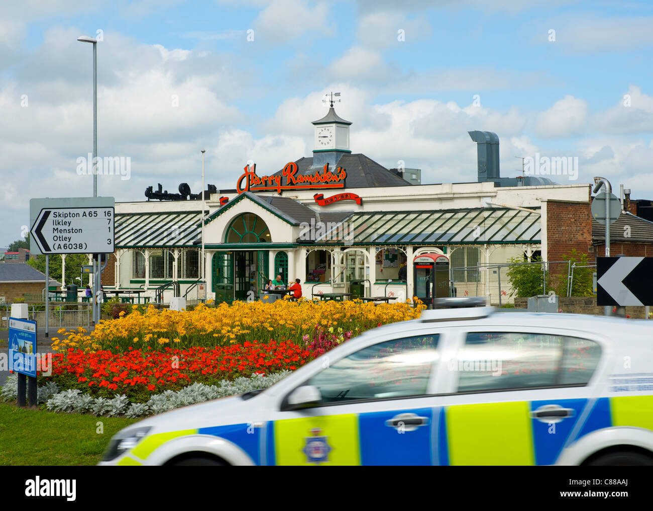 Polizei Auto vorbeifahrenden Harry Ramsden Fisch & chip Restaurant & Take-away, Guiseley, Leeds, West Yorkshire, England UK Stockfoto