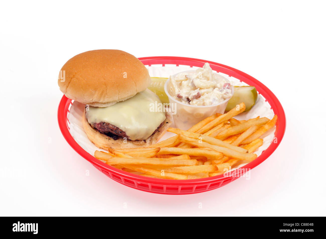 Cheeseburger mit Pommes Frites oder Chips, Kartoffeln, Salat und Gurke in rot Kunststoff retro Warenkorb auf weißem Hintergrund, Ausschnitt. USA Stockfoto