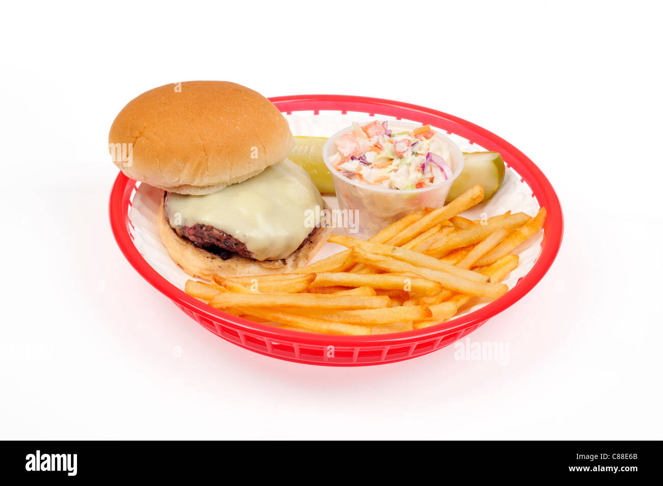Gegrillte Cheeseburger mit Pommes Frites oder Chips, Krautsalat und eine Essiggurke in einem roten retro Warenkorb auf weißem Hintergrund, Ausschnitt. USA America Stockfoto