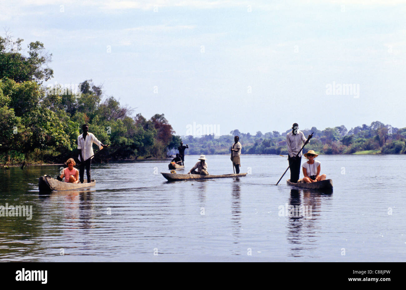 Sambia. Sambische Männer in ausgegraben Kanus, jeweils mit einem touristischen Passagier. Stockfoto