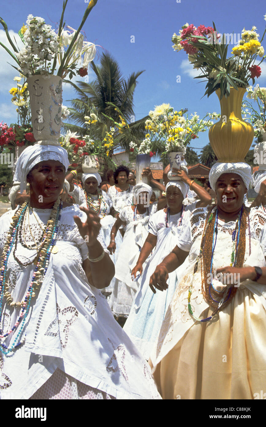 Insel Itaparica, Bahia, Brasilien. Baiana-Frauen, die Blumen auf dem Kopf für Iemanja Feier. Stockfoto