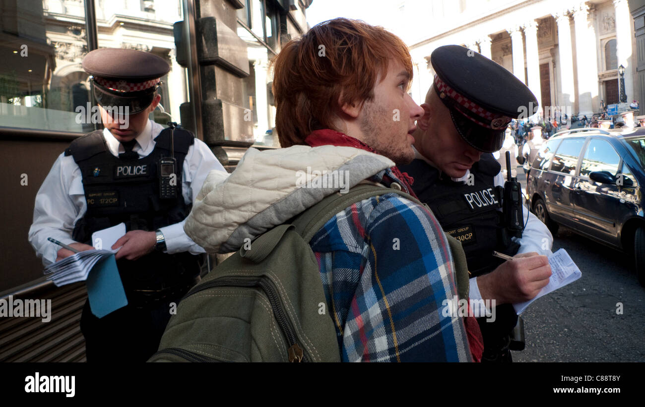 Occupy London Stock Exchange Demonstration 15/10/2011. Die Polizei kontrolliert den Zugang zur Demonstration an der St. Paul's Cathedral. Ein Polizist nimmt die Details eines jungen Mannes, bevor er ihm erlaubt, an der Hauptdemonstration auf den Stufen von St. Paul's in London England teilzunehmen. KATHY DEWITT Stockfoto