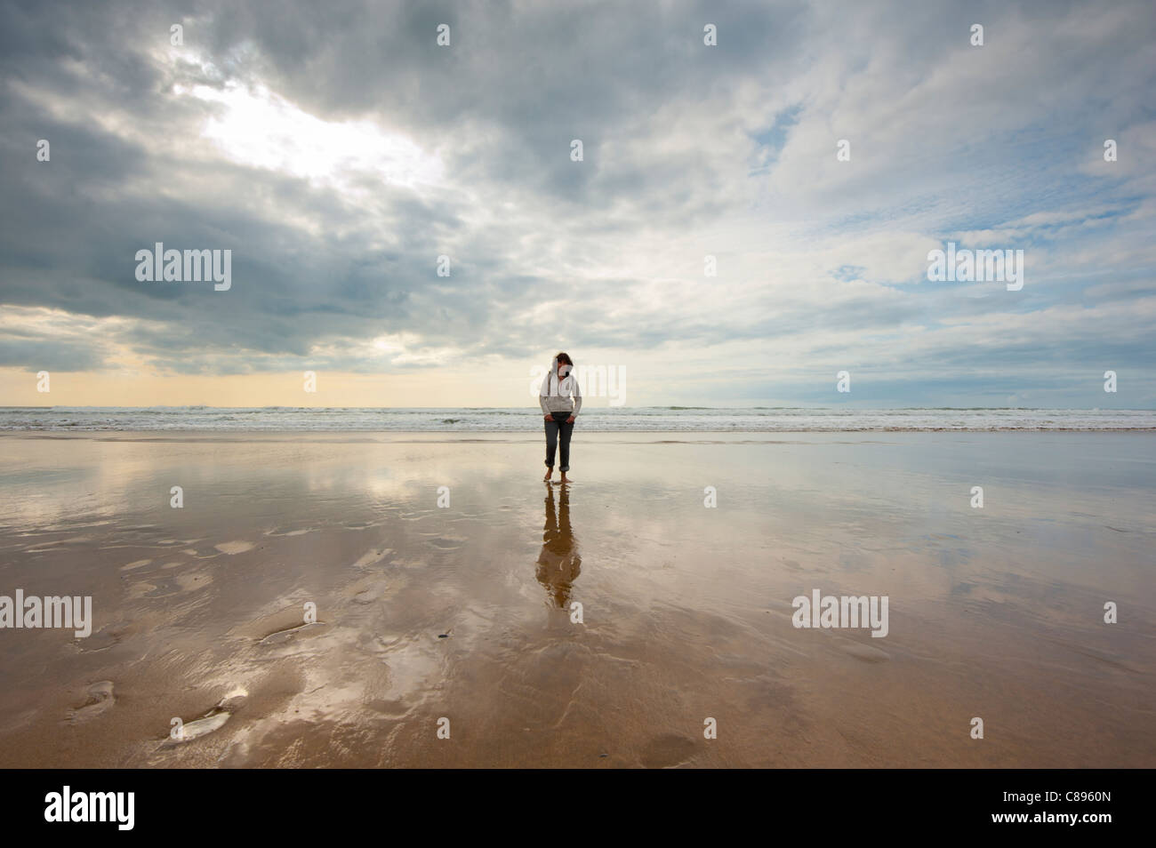 Frauen gehen am Strand, unter dramatischen Himmel Stockfoto