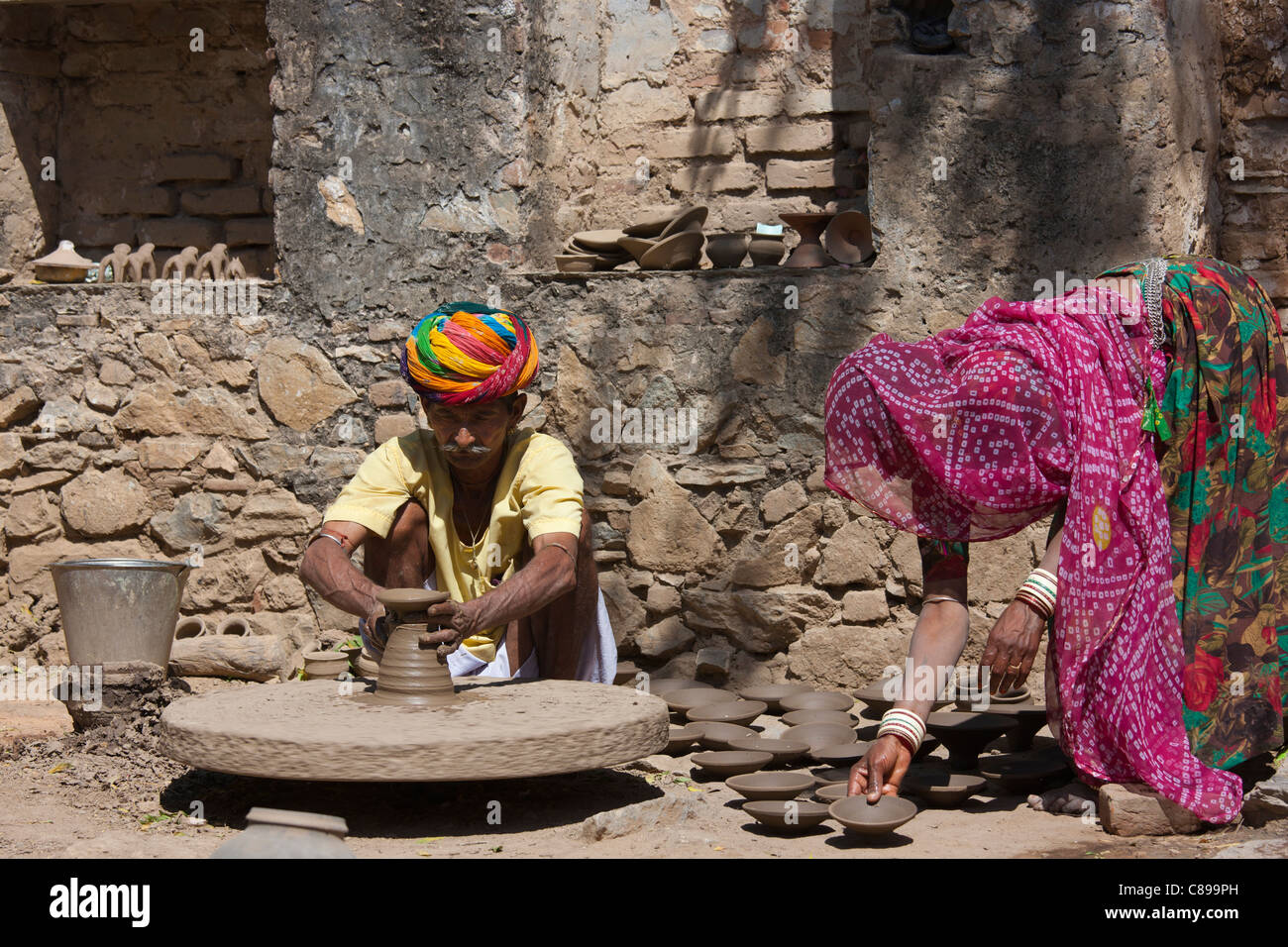 Indische Potter in Rajasthani Turban arbeitet zu Hause mit seiner Frau machen Tontöpfe in Dorf Nimaj, Rajasthan, Indien Stockfoto
