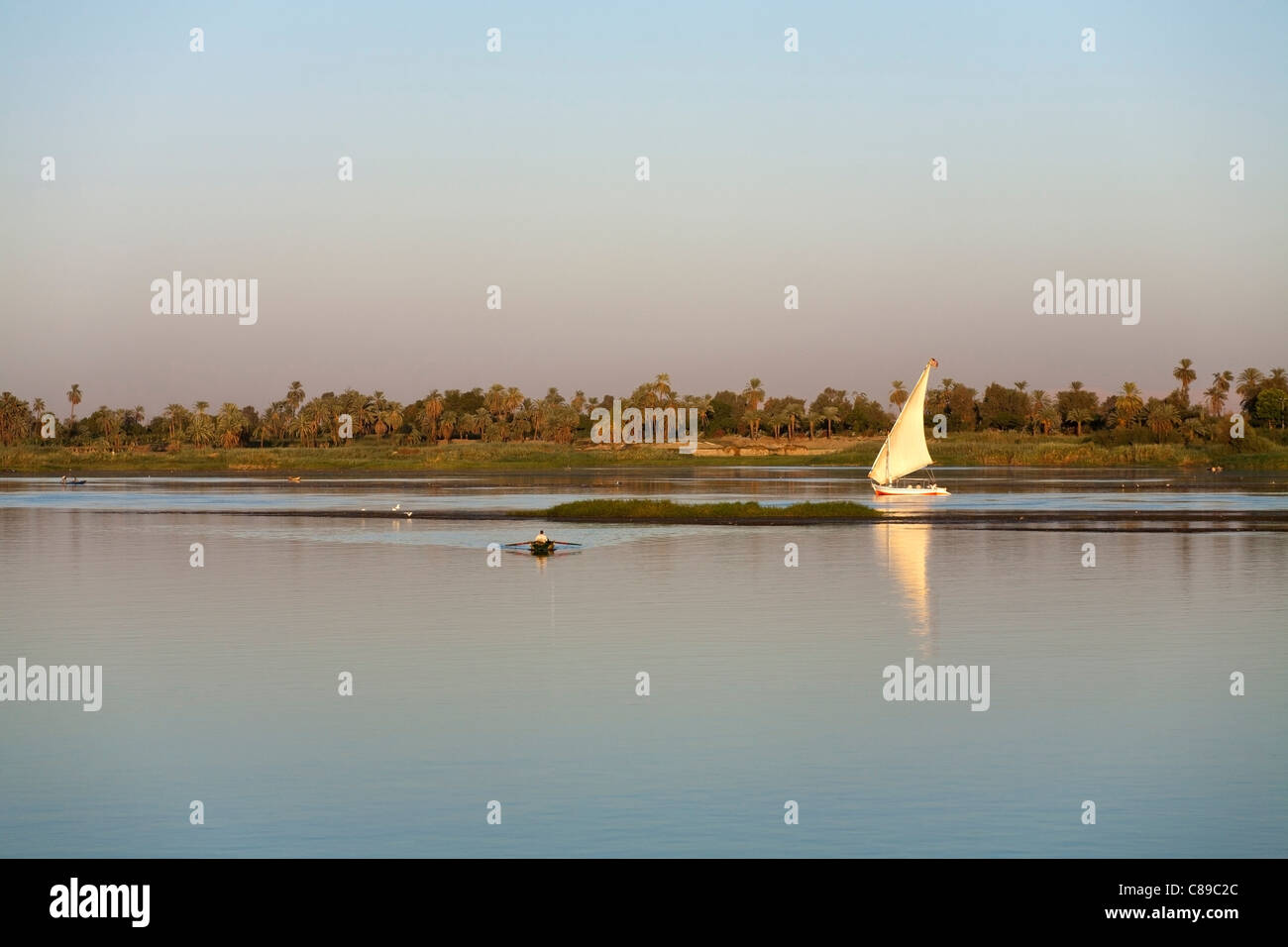 Nil-Abfahrt rechts nach links spiegelt sich auf ruhigem Wasser mit Palm Segeln Nil Bank hinter gesäumt von kleinen Fischerboot vor Stockfoto