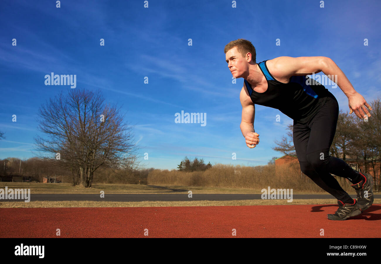 Mann in Sprint auf Sportstrack zu beschleunigen. Links Exemplar. Stockfoto