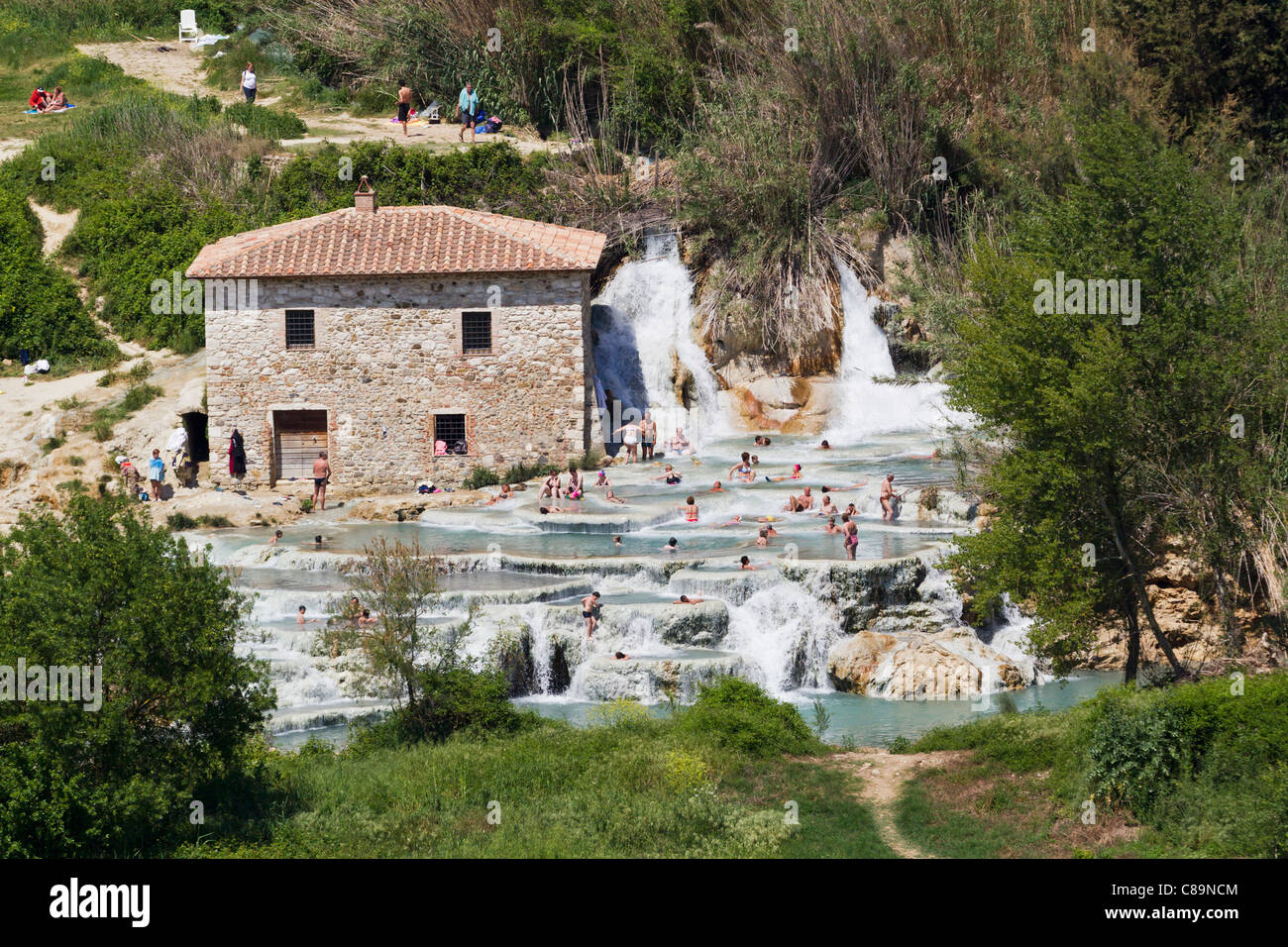 Italien, Toskana, Provinz Grosseto, Saturnia, Blick auf Menschen in thermischen Wasserfälle und Travertin am pool Stockfoto